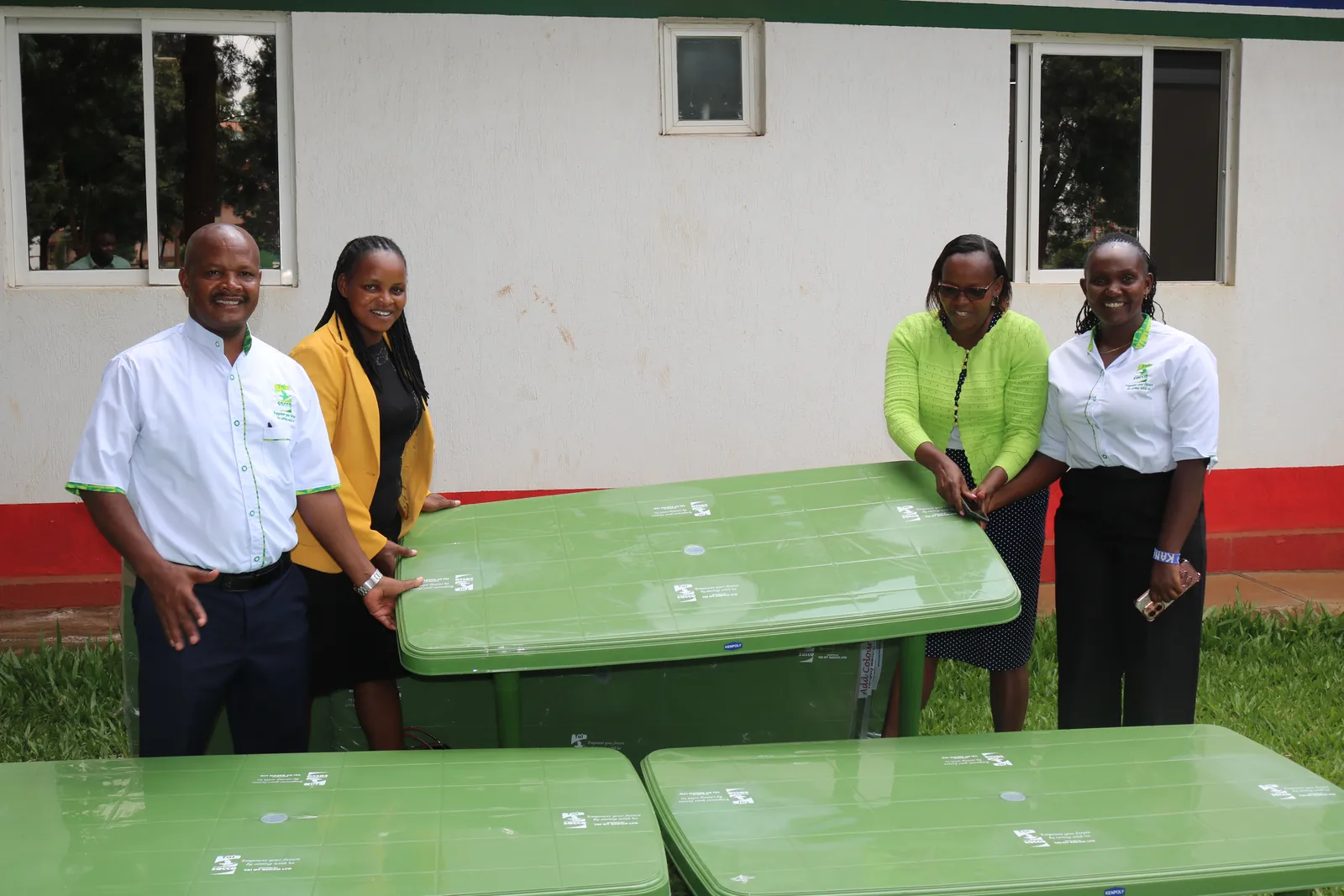 Tai Sacco staff handing over new desks to a school
