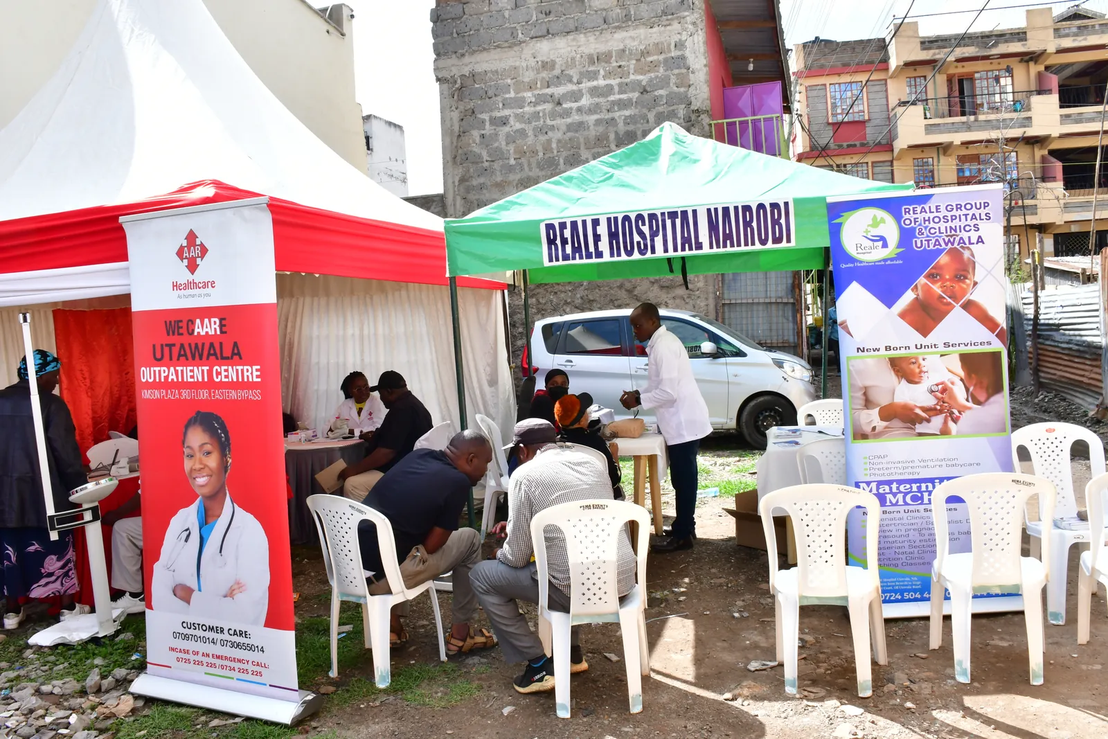 Hospital and clinic partners serving residents under tents at a community medical camp